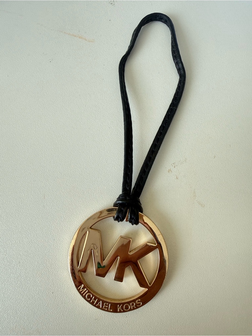 Michael Kors Gold MK Circle Logo Charm on Black Strap tassel